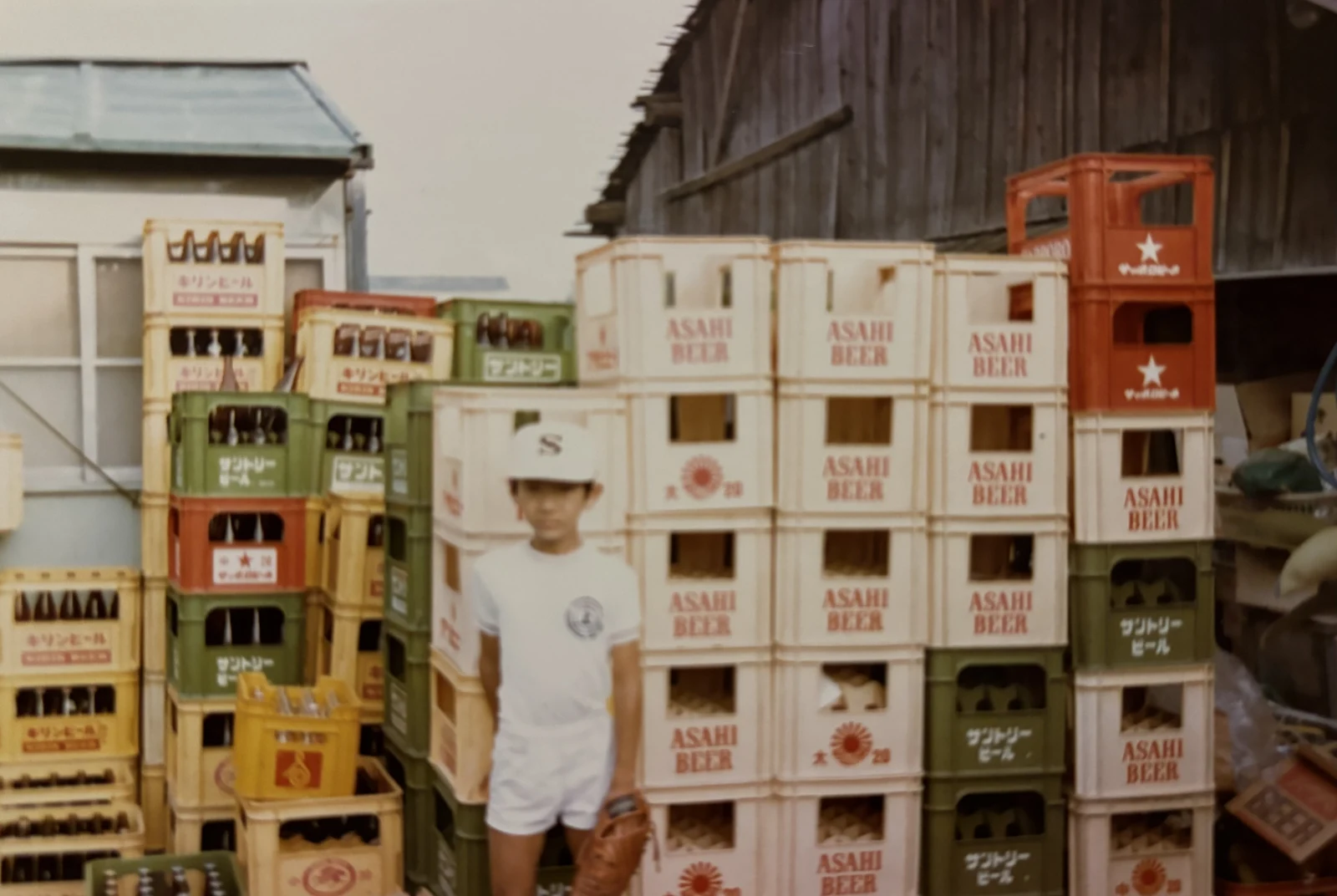 四代目 博志。ビール箱を積んだ店先で